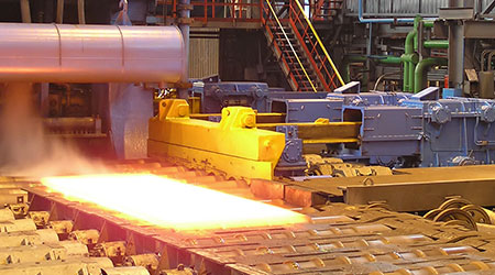 A steel sheet being transported in a hot steel mill production.